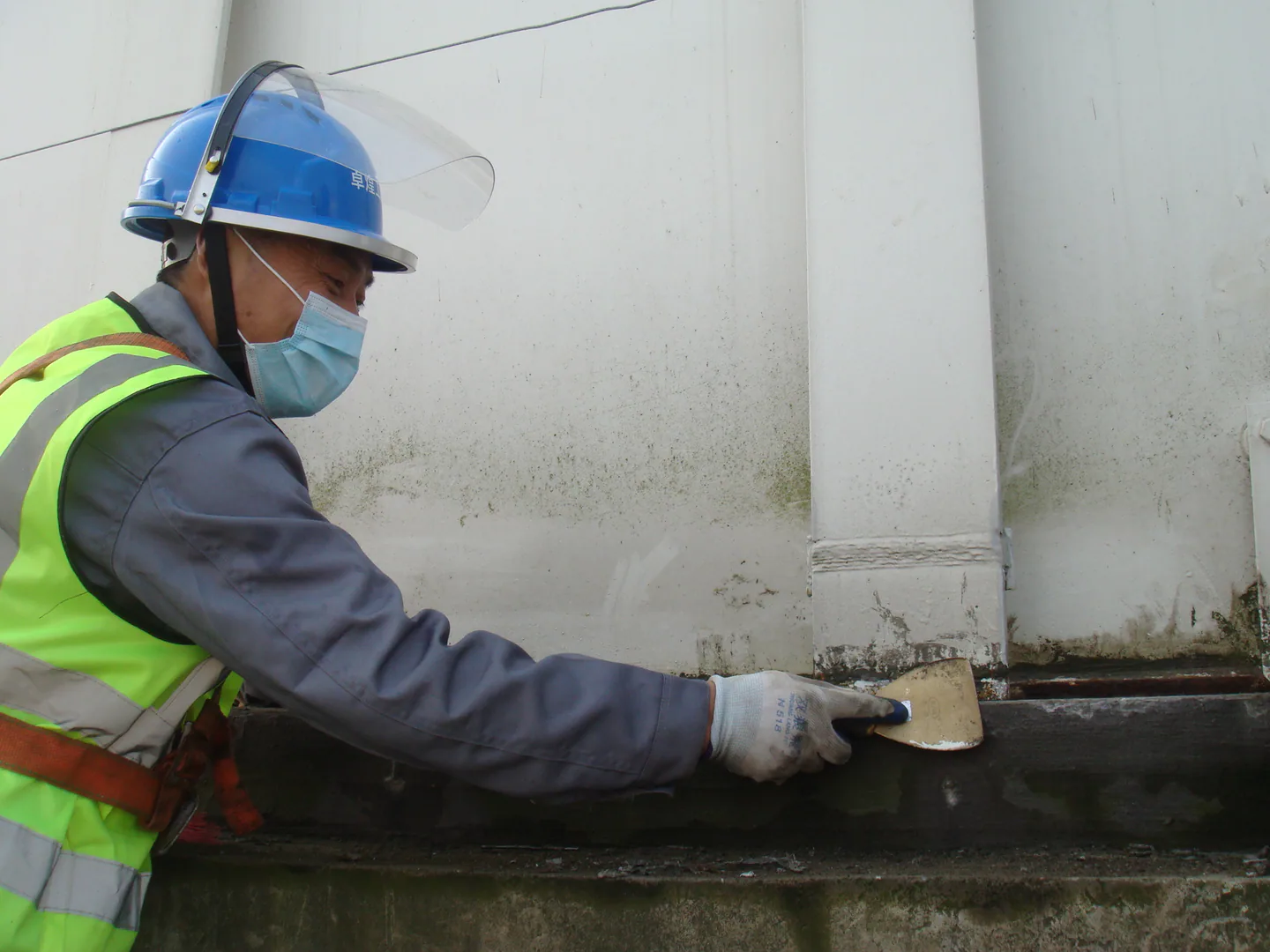 Petrolatum-based material being applied along the prepared tank edge transition.